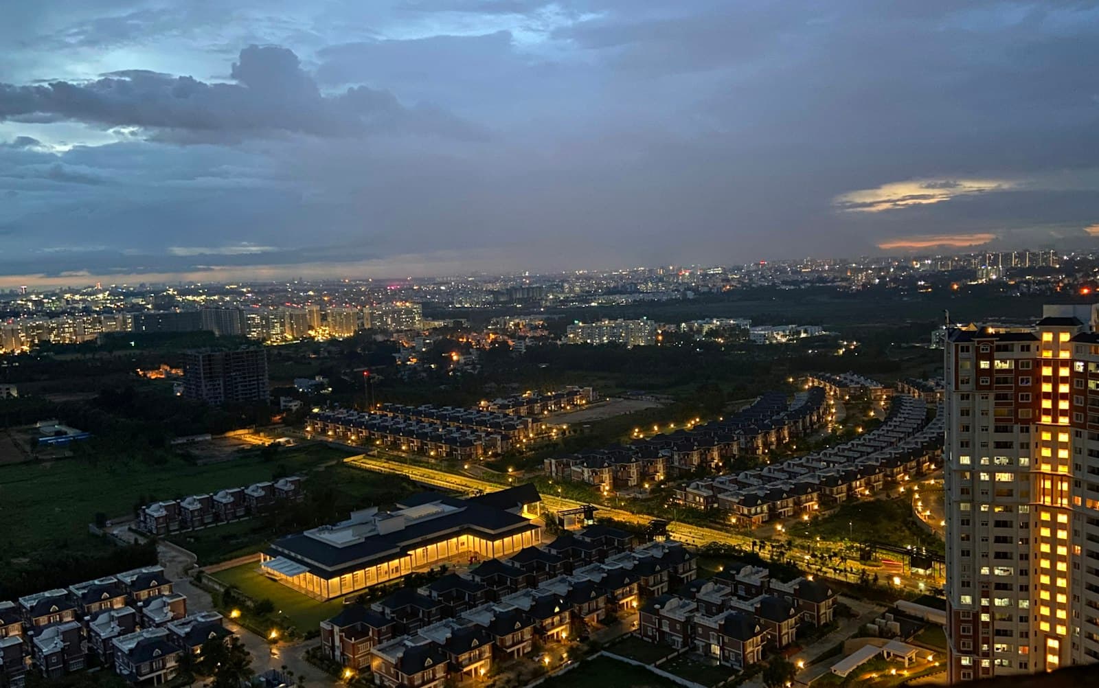 Bengaluru at dusk, photographed from above — hundreds of lit homes.