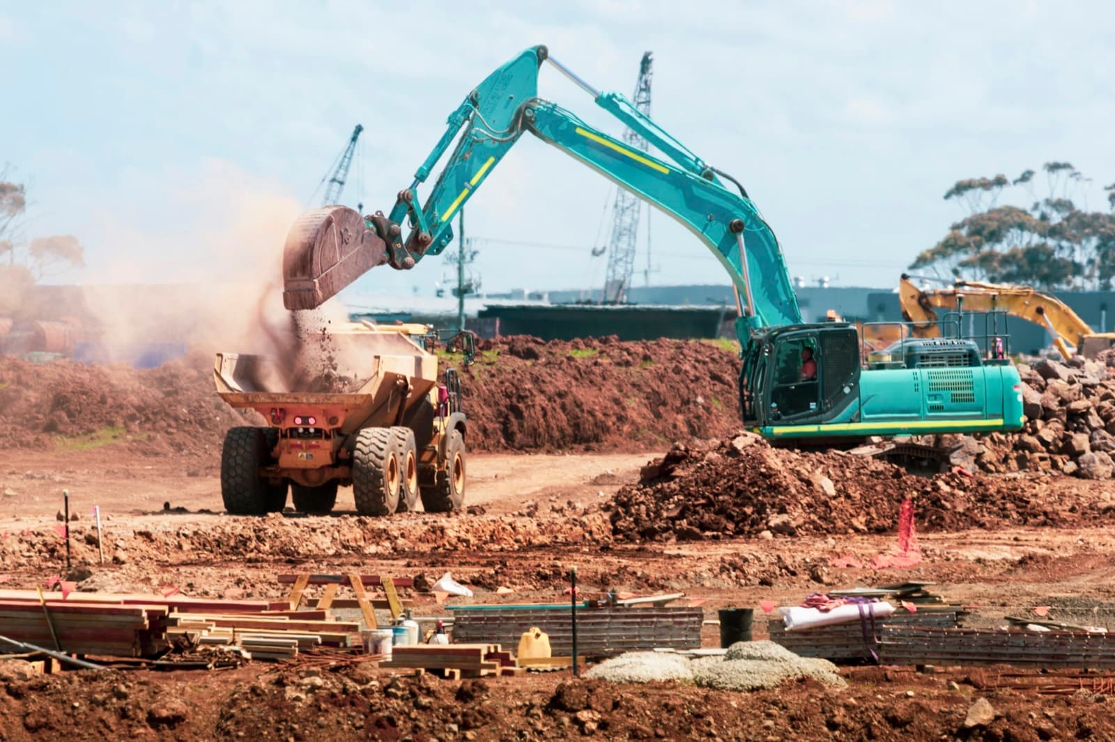 An excavator breaking ground on a site.