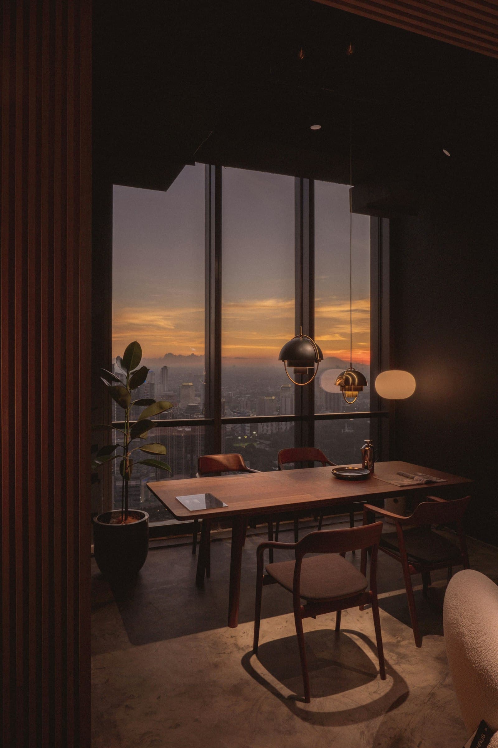 A let flat at dusk — a lamp on, the city in the window.